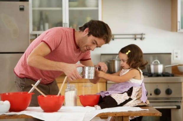 Father and daughter (2-4) baking in kitchen, side view