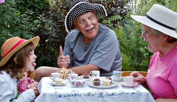Grandparents and beautiful grandaughter having fun at a tea party