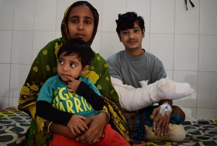 In this photograph taken on January 4, 2017, Bangladeshi man Abul Bajandar, (R) widely known as 'Tree Man' for his rare disease, relaxes with his family on a ward at The Dhaka Medical College Hospital in Dhaka. A Bangladeshi father dubbed the "tree man" because of the bark-like warts that once covered his body will soon be able to leave hospital after surgery being hailed as a milestone in treating one of the world's rarest diseases. / AFP PHOTO / Sam JAHAN