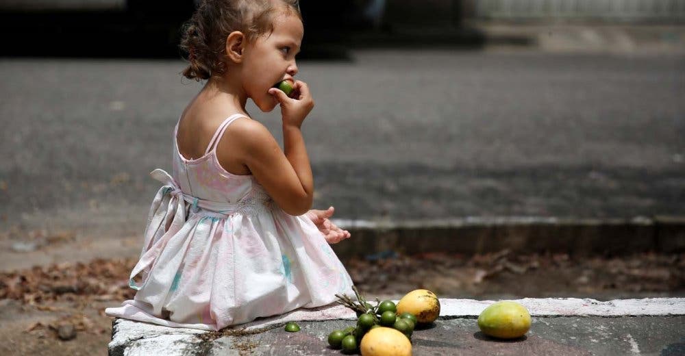 Unos niños venezolanos engañan el hambre con frutas podridas desechadas en un mercado Unos niños venezolanos engañan el hambre con frutas podridas desechadas en un mercado