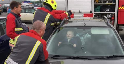 Un bebé que se queda encerrado en un auto se ríe mientras los bomberos intentan rescatarlo