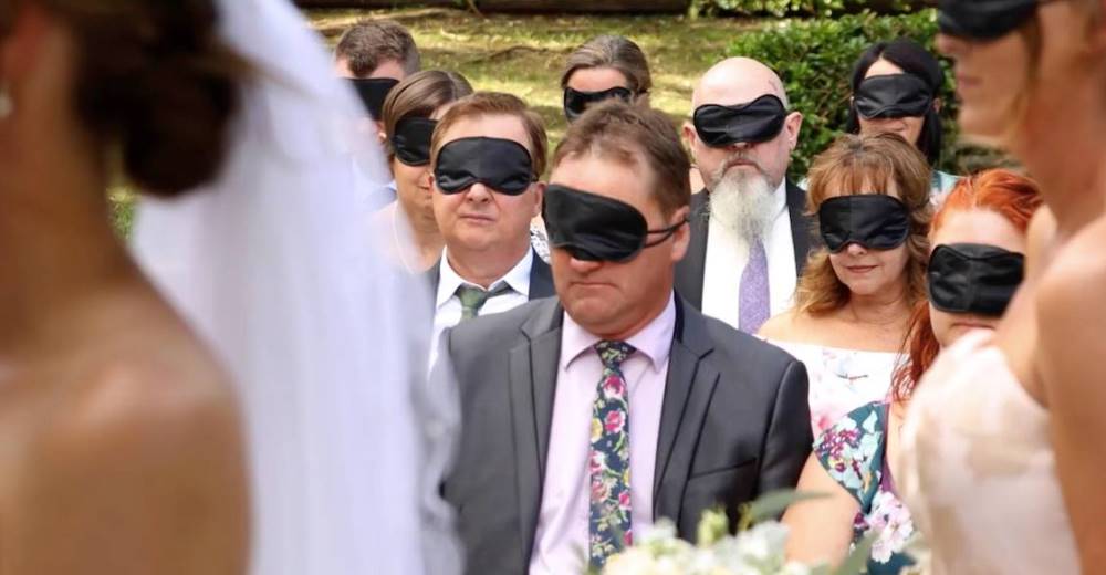 Los invitados esperan que los novios se acerquen al altar con los ojos vendados