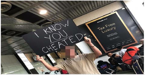 Espera a su esposa en el aeropuerto con un cartel que deja en evidencia su infidelidad