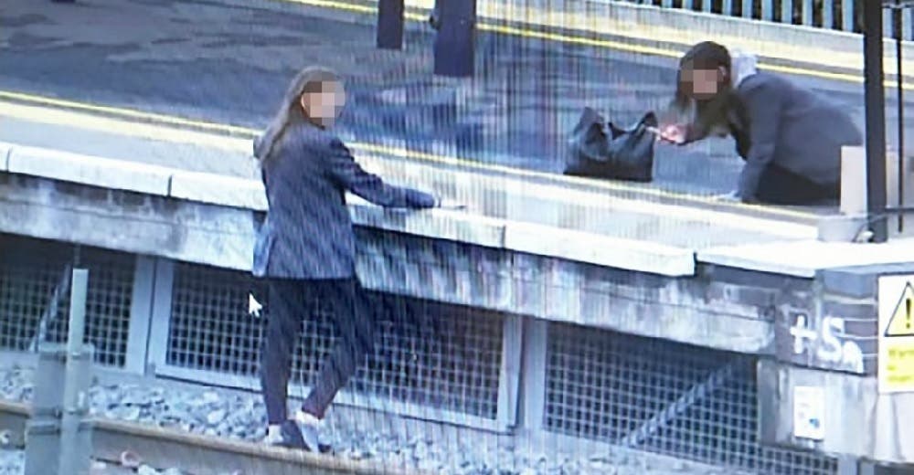 No temen arriesgar su vida y posan para fotografiarse en medio de las vías de un concurrido tren No temen arriesgar su vida y posan para fotografiarse en medio de las vías de un concurrido tren