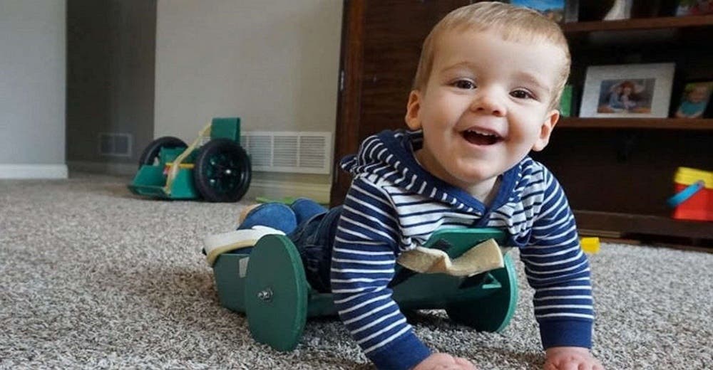 Bebé con espina bífida que no podía moverse logra gatear gracias al curioso invento de su padre