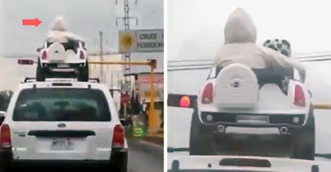 Graban cómo 2 niños viajan sobre el techo de un vehículo sentados sobre su auto de juguete