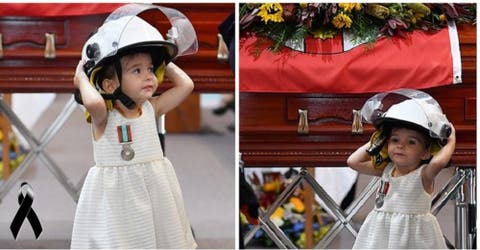 La hija de un bombero fallecido usa su casco y se niega a separarse del féretro