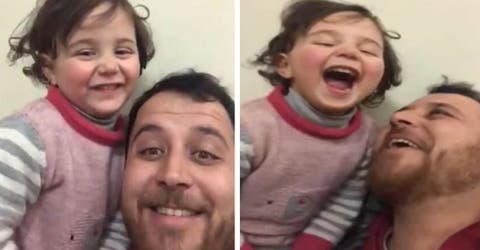 Hace reír a su hija con un juego mientras se escuchan las detonaciones de las bombas en Siria