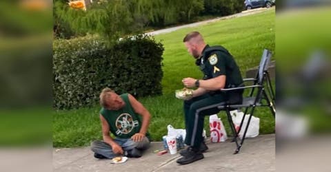 Un policía se acerca a un indigente con su comida sin saber que era visto por una pareja