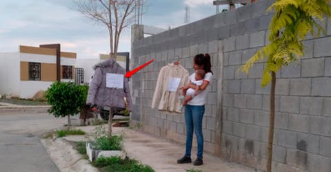 Una madre ofrece prendas de ropa en la calle a cambio de pañales o alimentos para su bebé