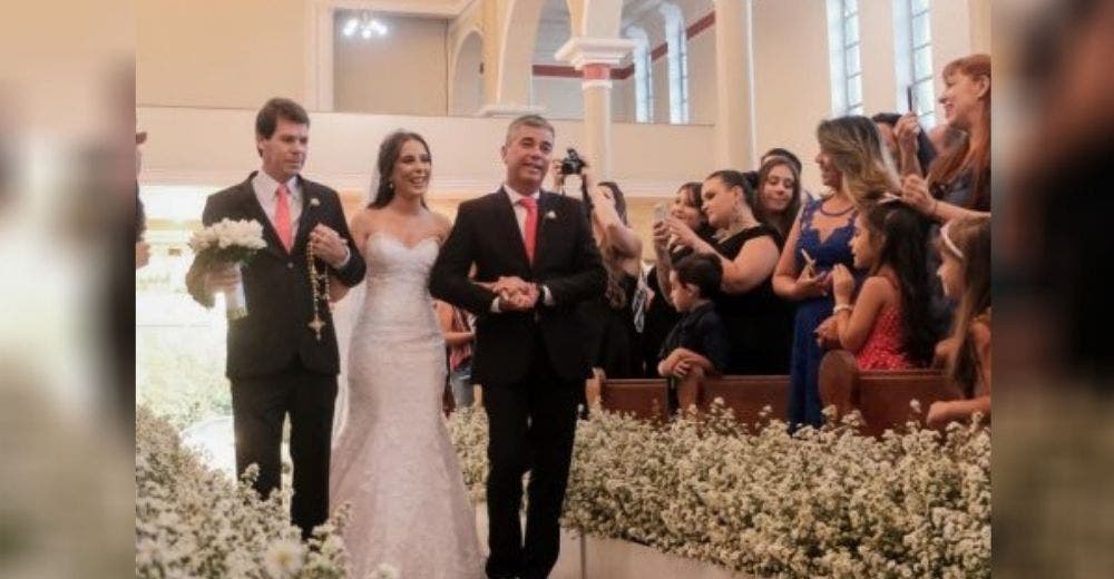 Camina al altar del brazo de 2 hombres desconcertando a los invitados