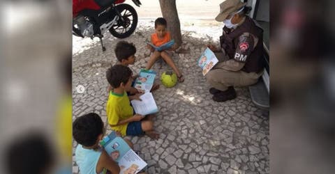 Un policía se acerca a un grupo de niños desfavorecidos sin saber que alguien los fotografiaba