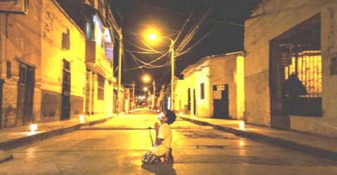 Un niño se arrodilla en plena calle durante la noche a rezar sin saber que alguien lo escuchaba