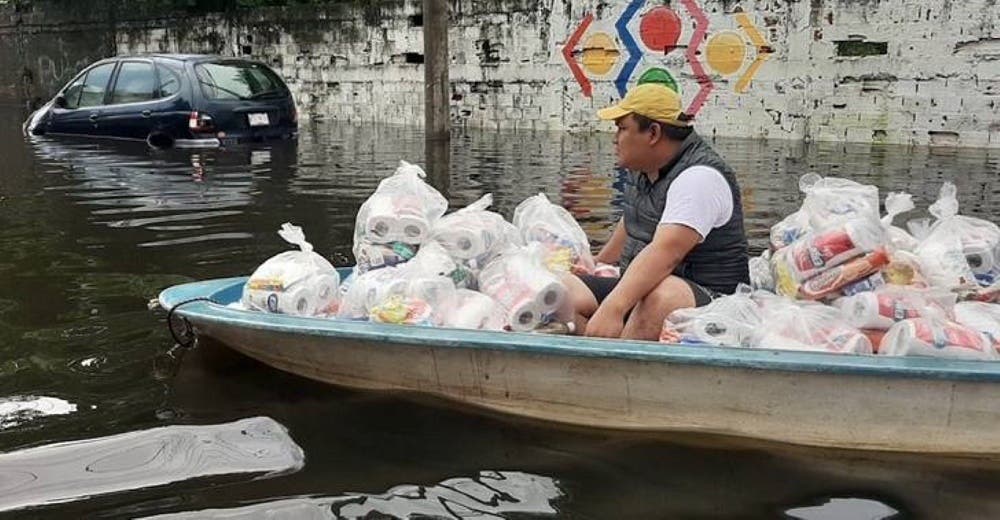 Un sacerdote se despoja de su sotana para subir a un bote y ayudar a quienes lo perdieron todo