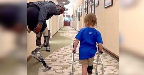 Un atleta paralímpico ayuda a un niño de 2 años a dar sus primeros pasos con una prótesis
