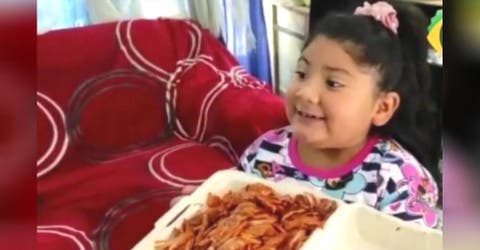 Una niña pide en una carta platos de comida y refrescos para su familia
