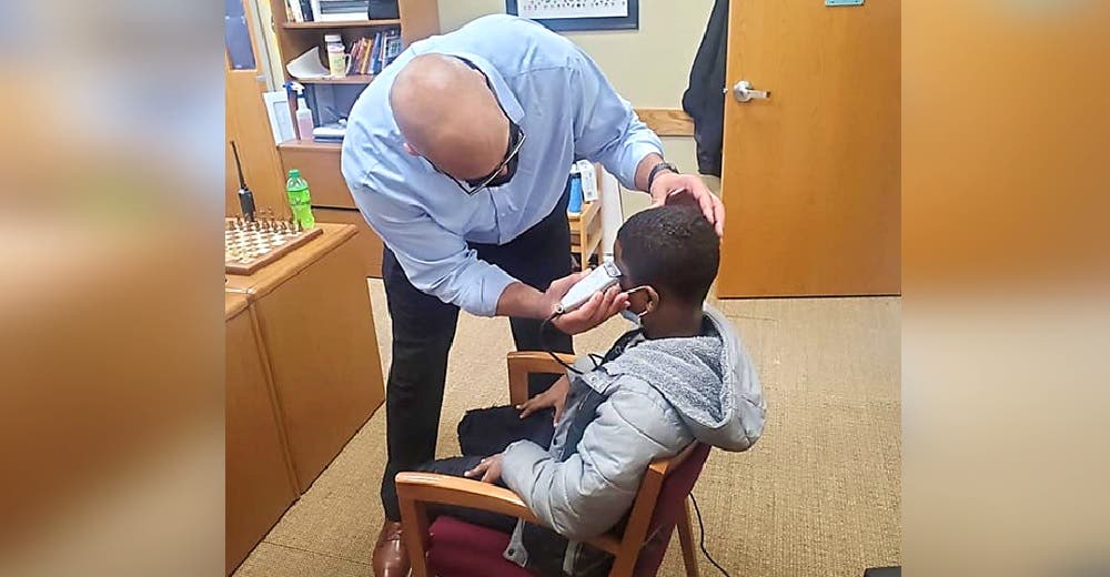 El director de la escuela se acerca al niño que se negaba a quitarse su sombrero en la clase