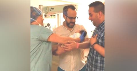 2 hombres reciben a su hija recién nacida en brazos y celebran a pesar de los señalamientos