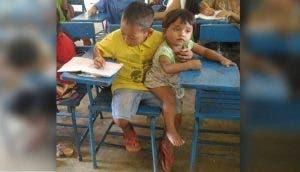 La imagen de un humilde niño que llevó a su hermana de 1 año a clase conmueve al mundo