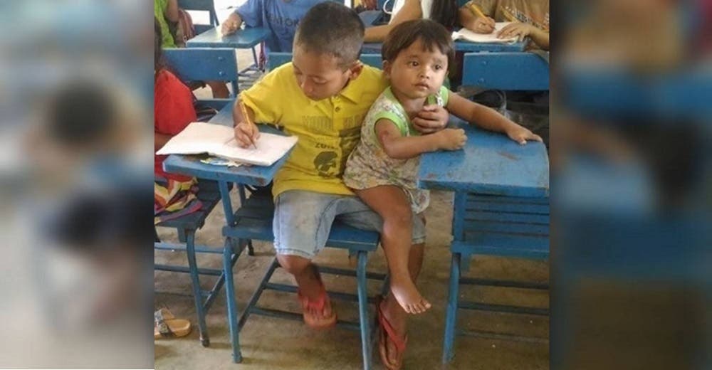 La imagen de un humilde niño que llevó a su hermana de 1 año a clase conmueve al mundo